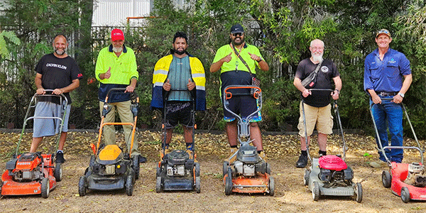 Six students stand outdoors beside lawnmowers during CCNI’s Introduction to Small Engines workshop at Moree Campus, where learners developed practical maintenance and workshop skills in a hands-on community learning environment.